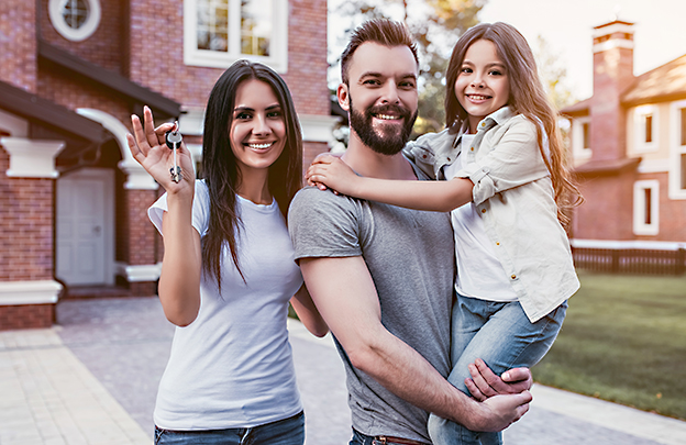 Family outside a house holding keys.